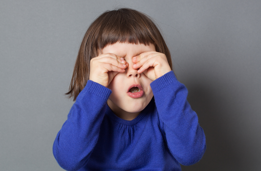 Photo of a little girl rubbing her eyes