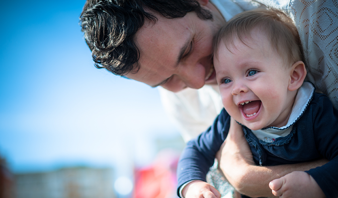 Photo of a happy father holding his child