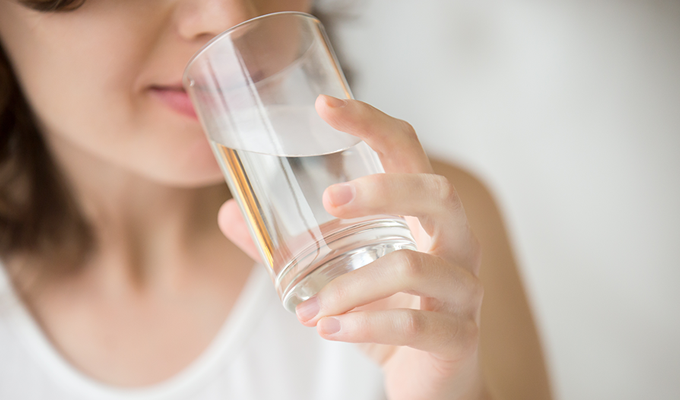 Closeup of a woman drinking a glass of water