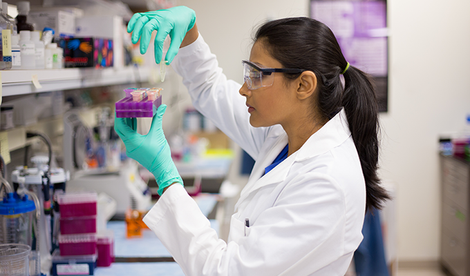 Photo of a lab technician analyzing a sample