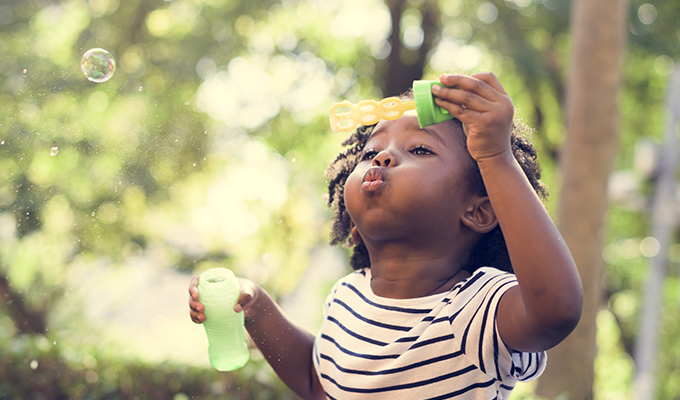 Photo of a young girl blowing bubbles